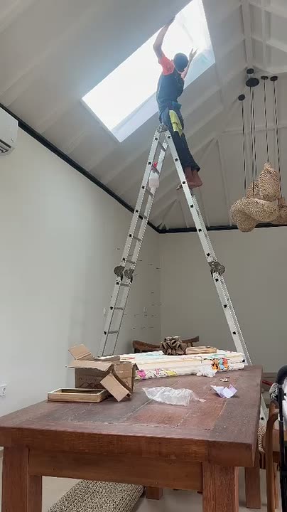 Pemasangan kaca film pada skylight menggunakan tangga tinggi